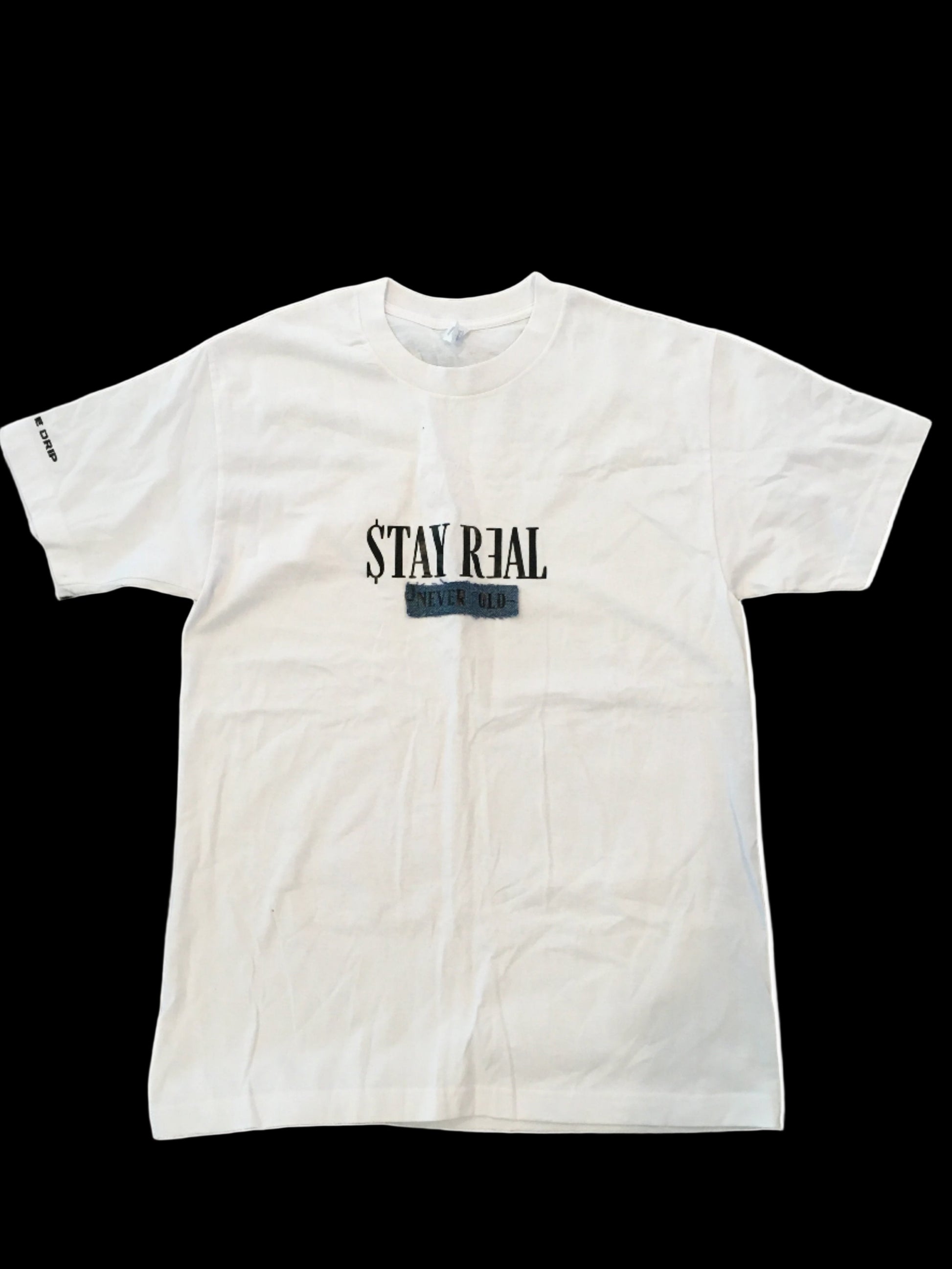 White cotton T-shirt featuring a denim patch with "Stay Real" in the center. "Creative Drip" is printed on the right sleeve for a subtle branded touch. Comfortable and versatile for everyday wear.